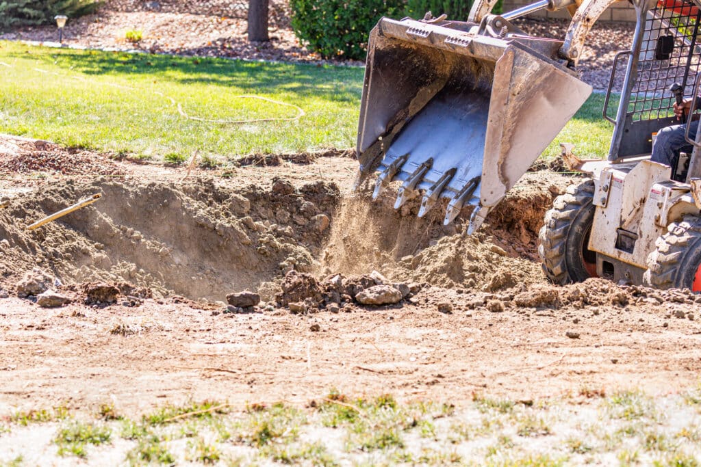 Skid steer digging in a front yard